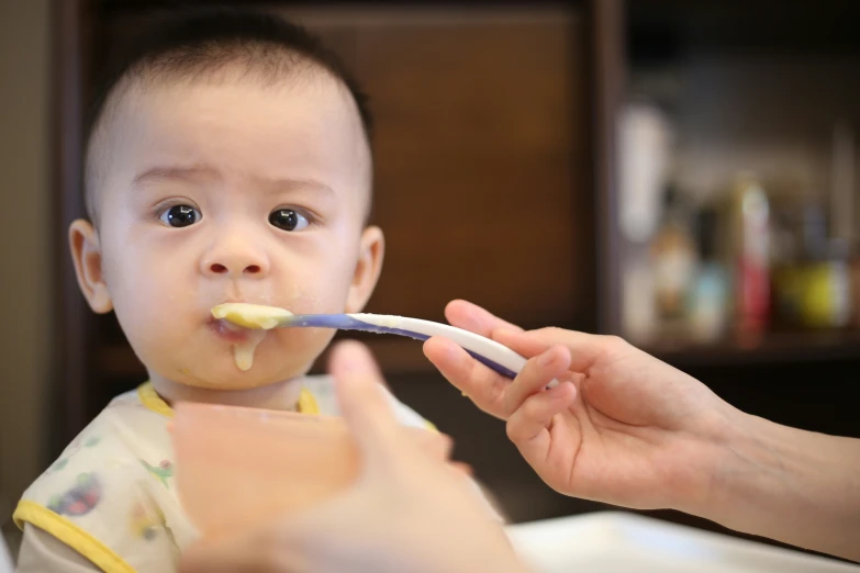 the baby is brushing his teeth with a blue toothbrush