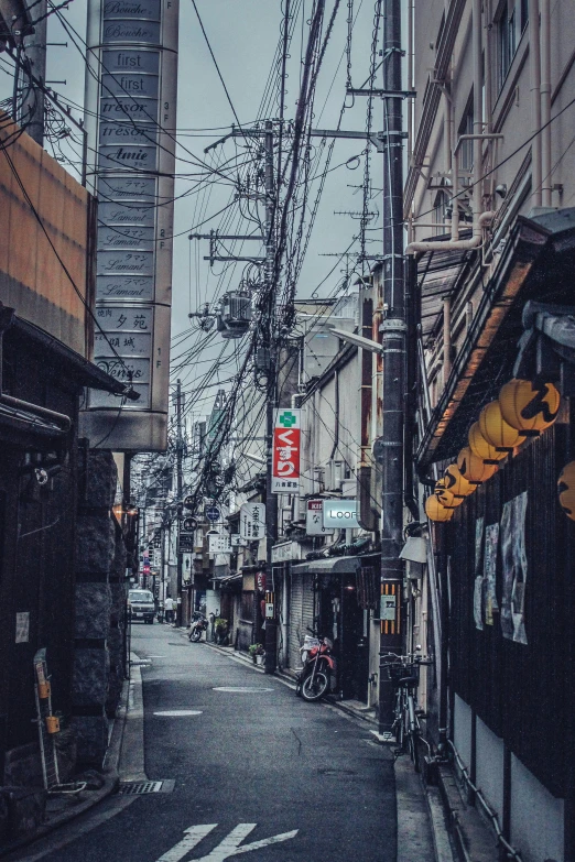 an old street is pictured through the wires