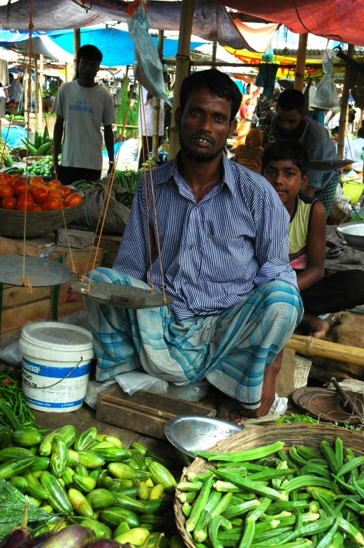 a man is sitting in front of some baskets filled with produce