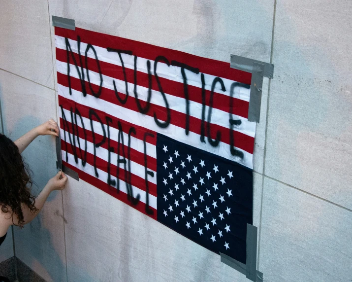 a woman putting letters on a sign that says and american flag