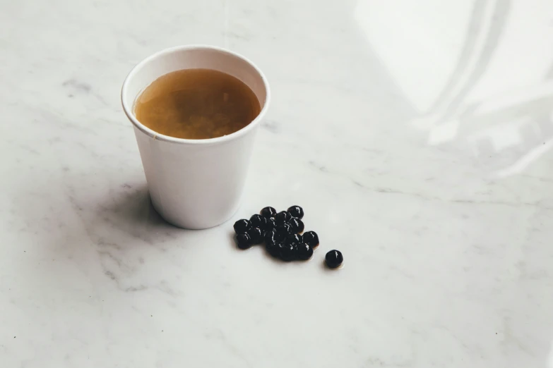 a cup of coffee with beans on the side