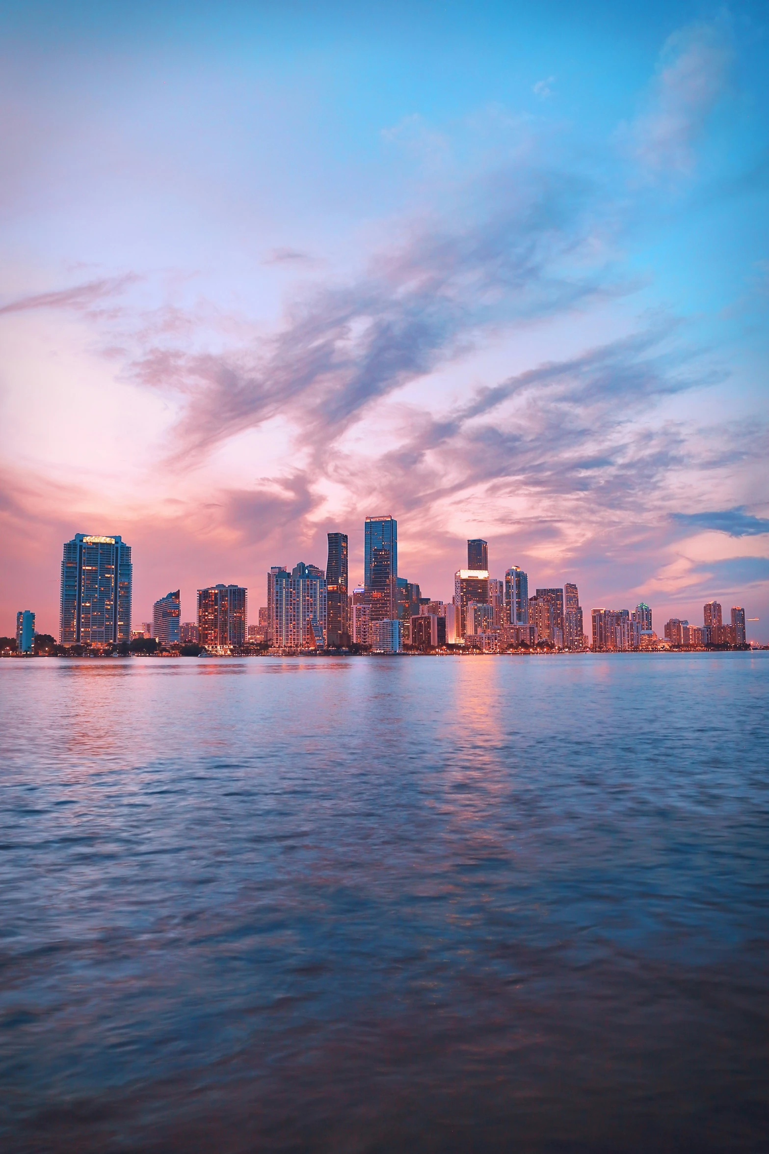 the cityscape is reflected in the water