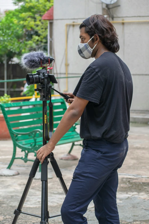 a camera man with a protective face mask and a camera