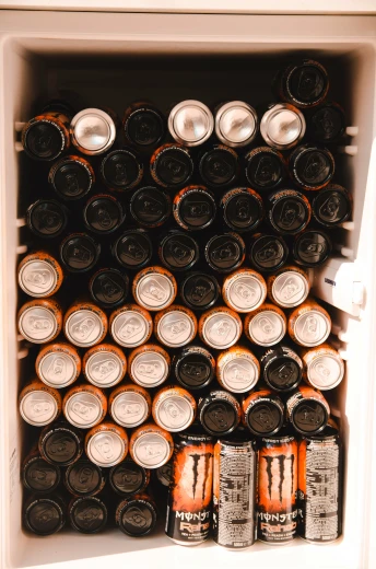 a white refrigerator filled with lots of beer cans