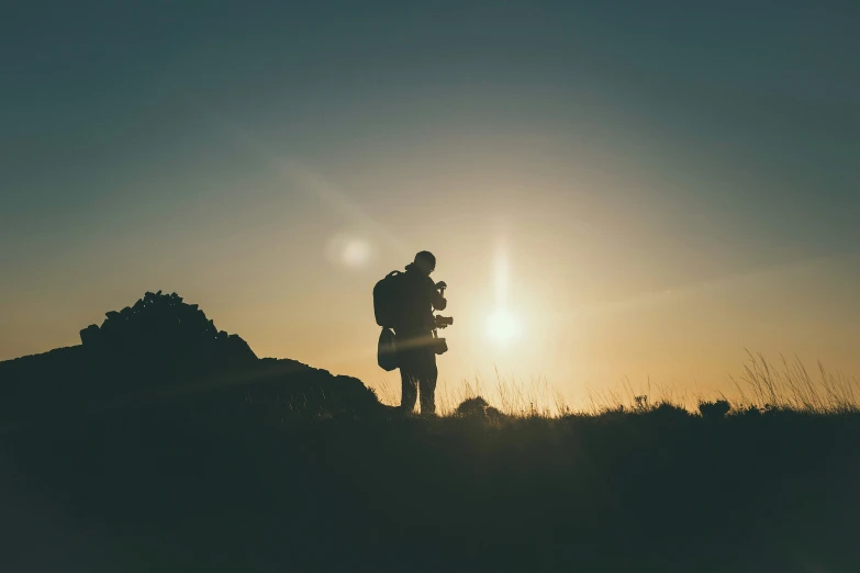 a silhouette image of a hiker against the sun