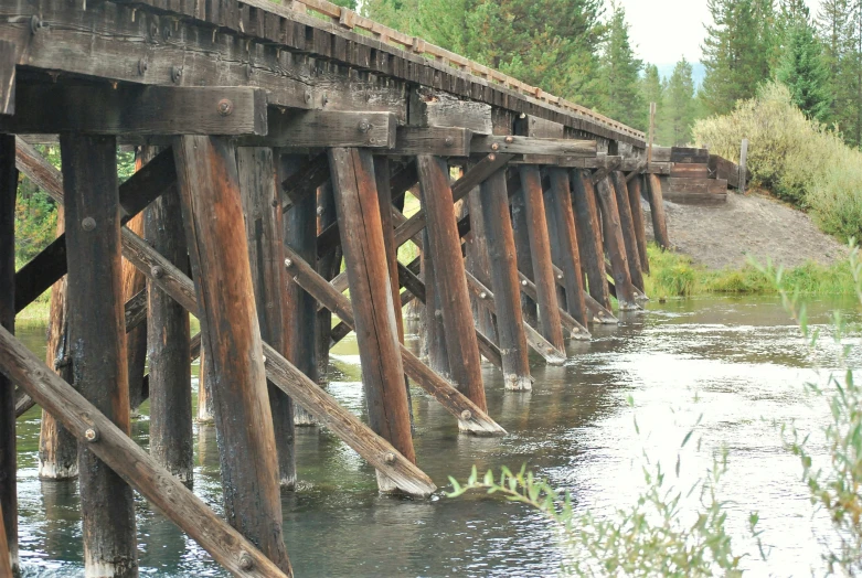 an old wooden bridge is partially covered by water