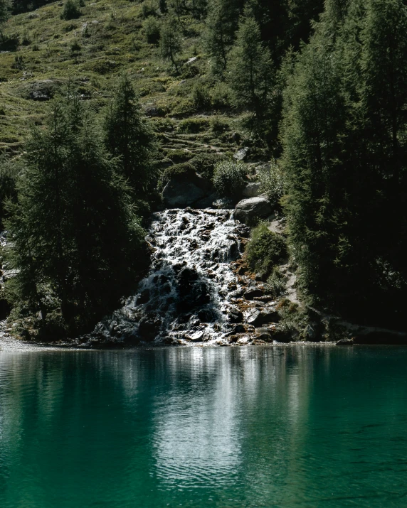 a large body of water near a lush green hillside