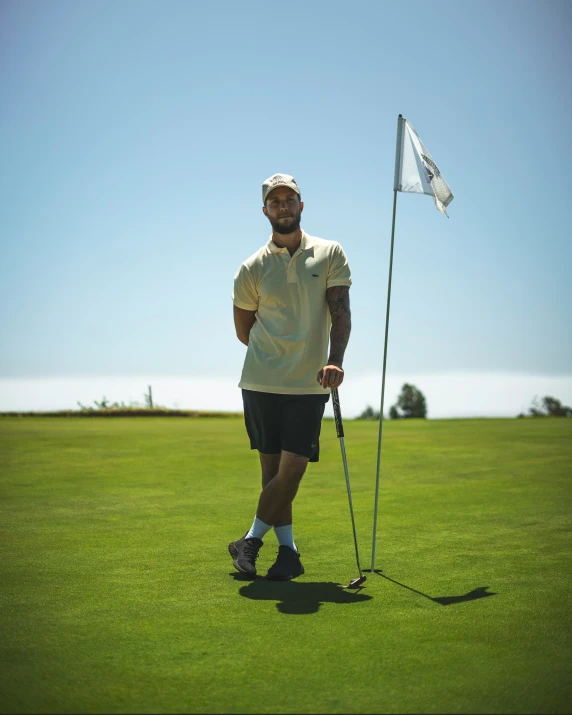 a man in shorts and a white shirt stands behind a white flag