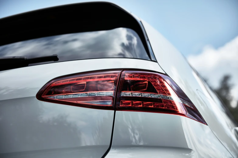 the rear end of a white vehicle with bright red leds