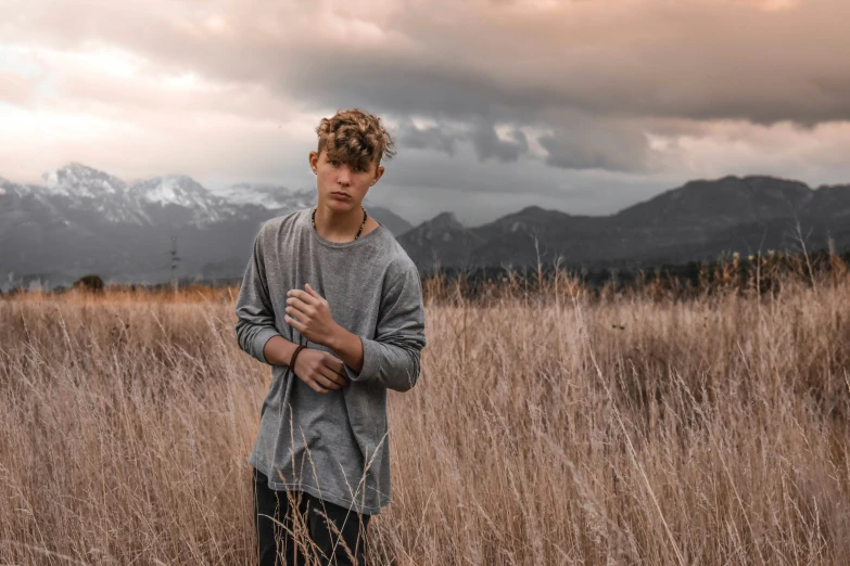 a man standing in tall grass on a field