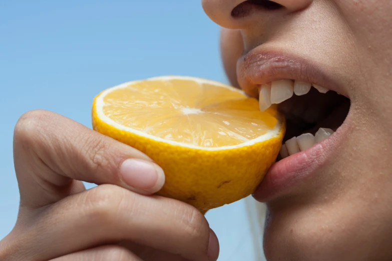 a woman is eating an orange and it's really ripe