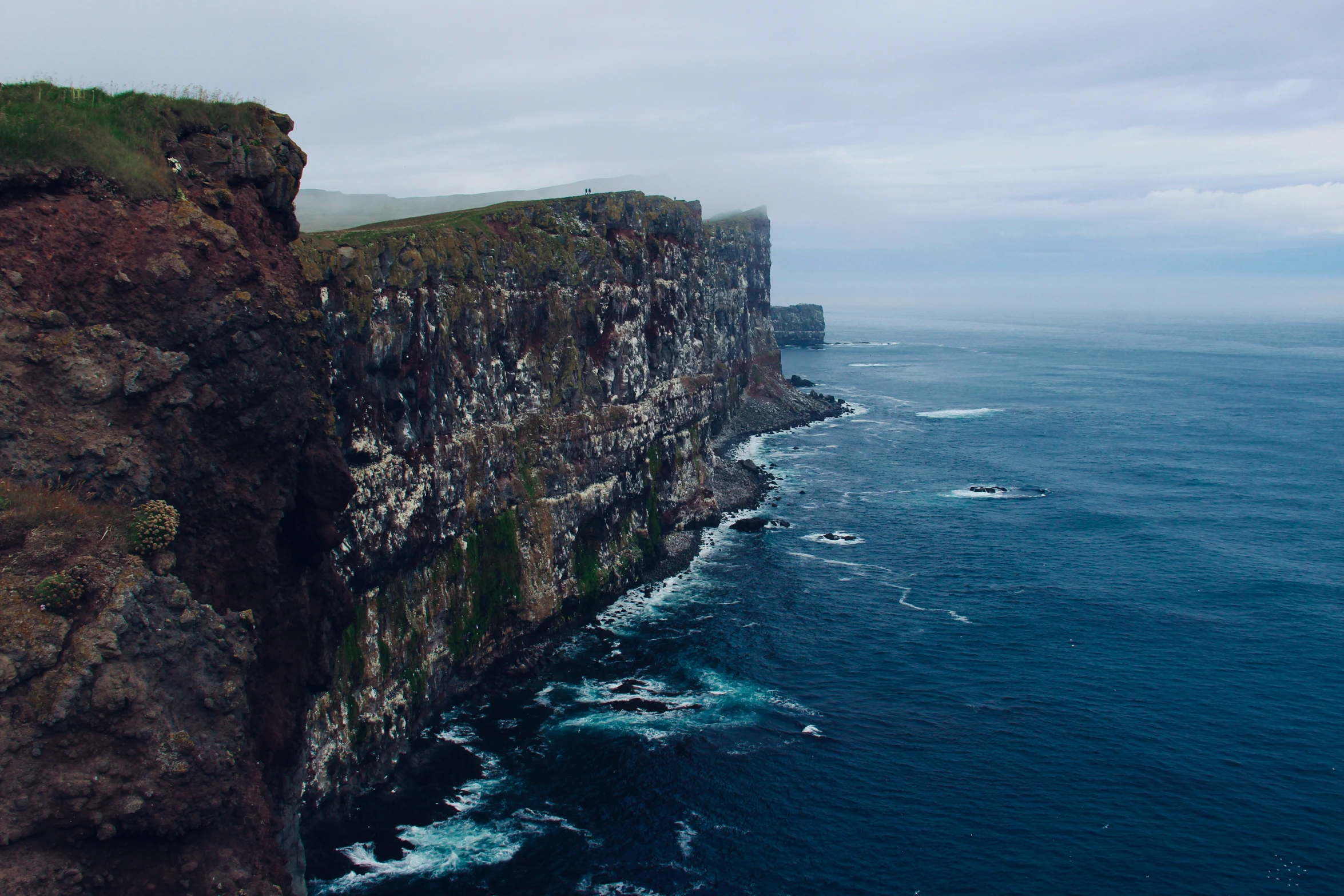 the ocean below a cliff with lots of water