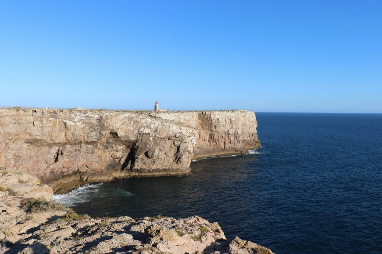 the person stands on top of a large cliff