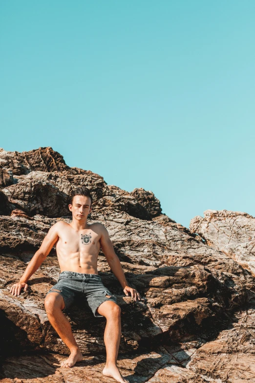 a man in shorts and  on top of some rocks