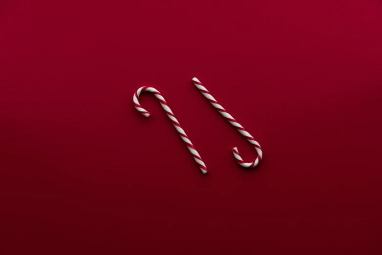 candy canes lie on top of red surface