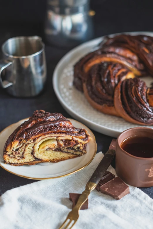 two plates topped with cinnamon roll and a cup of coffee