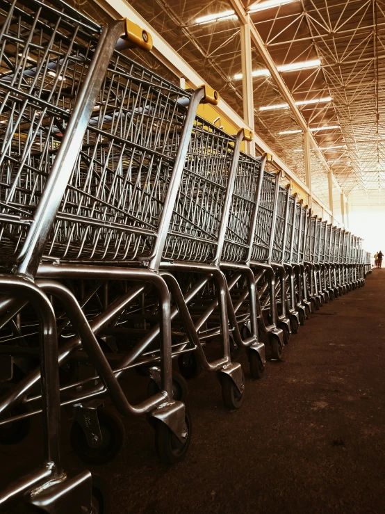 multiple rows of carts in a building with some people standing nearby