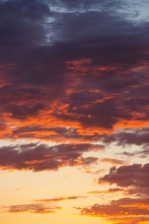 an airplane is flying against a purple and orange sky