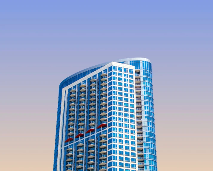 a tall glass building with red flag posts in front