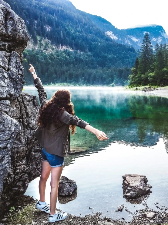 the woman is reaching her arms out to the water