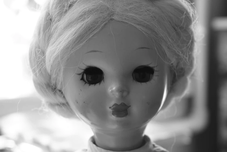 a black and white po of an old doll with eyelashes