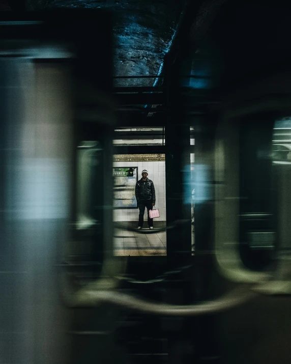 the inside of a subway station with two people standing at the platform