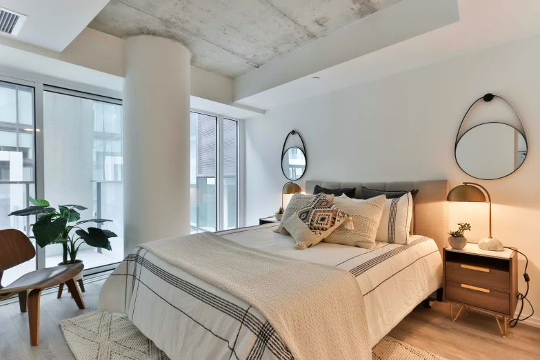 a bedroom with a large bed, wooden furniture, and big windows