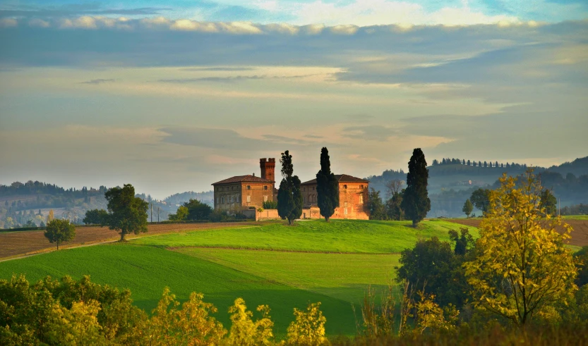 this is a view of a farm with a lonely house in the distance