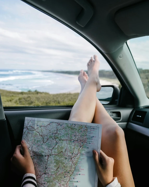 someone sitting in their car reading a map