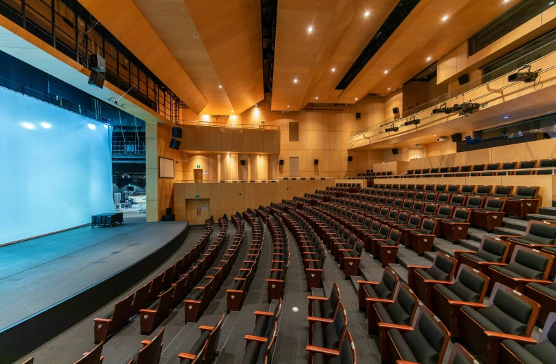 a large projection screen and chairs inside a building