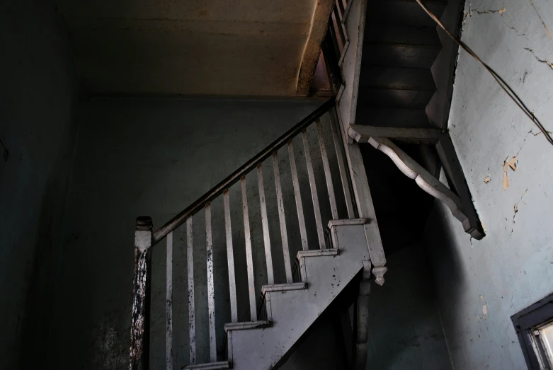 a stairwell in a dilapidated house with stairs