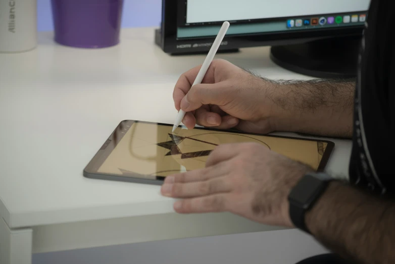 a man is holding a pen and a small square device