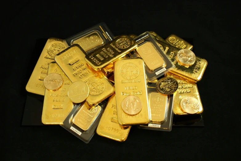 a pile of gold bars and coins that are shiny and gold