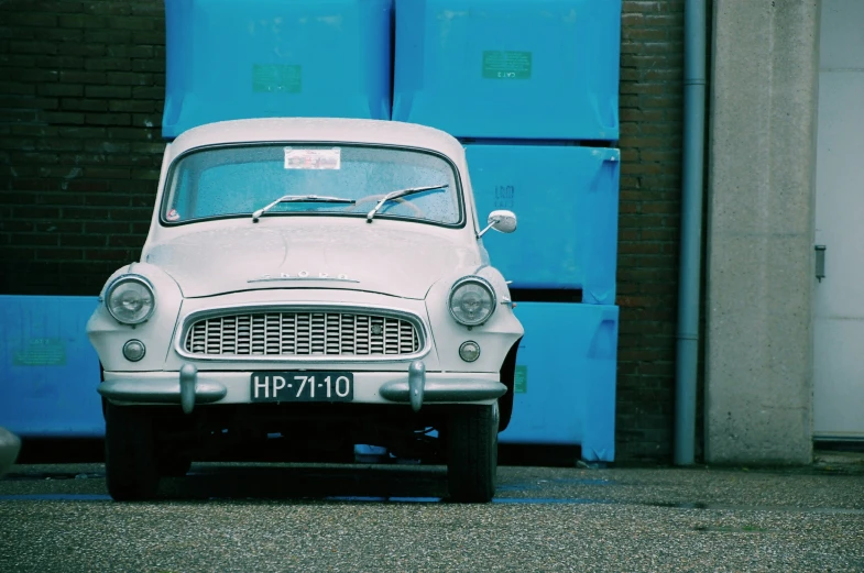 an old car is parked in front of a brick building