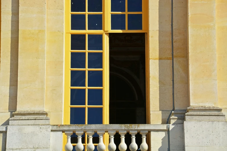 two open windows on a wall near a stone bench