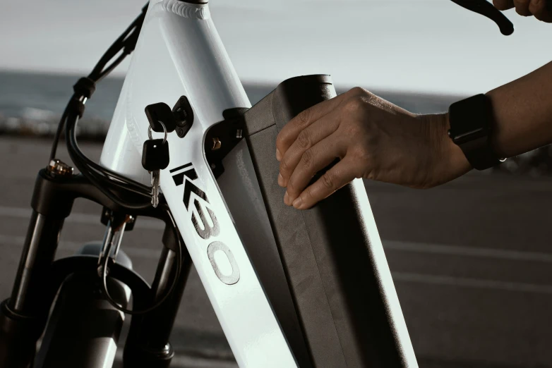 a close up of a person holding a bicycle near the ocean