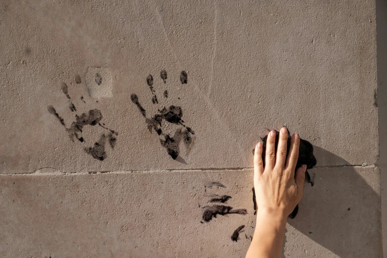 a person's hand and footprints on the ground