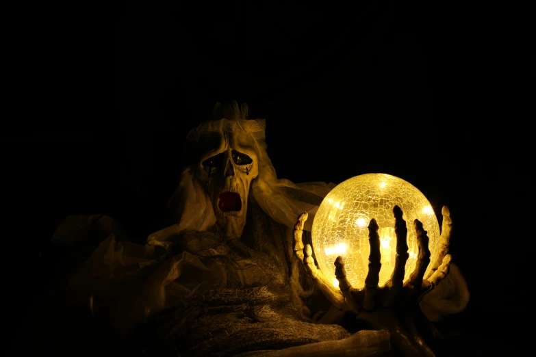 a lighted, scary figure with long hair holds up a light