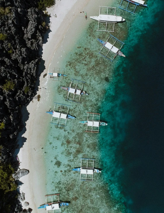 aerial view of two boats tied together near a sandy beach