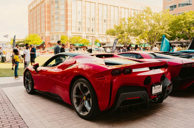 two red sports cars parked next to each other on the ground