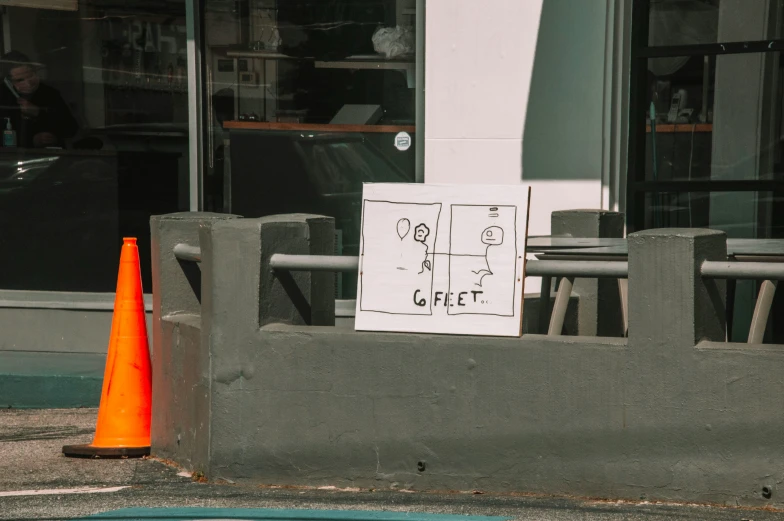 orange traffic cones are near the sidewalk of a building