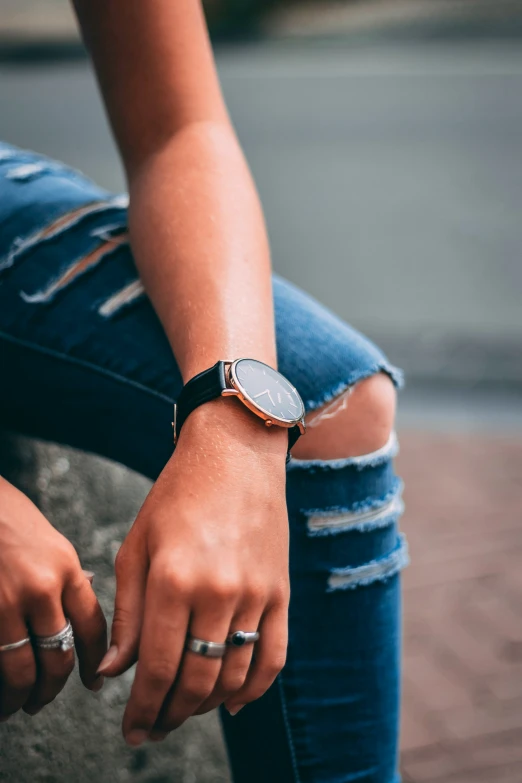 a woman holding onto her wrist with an open watch on it