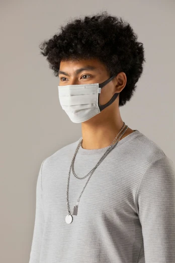 a man in a gray sweater wearing a face mask