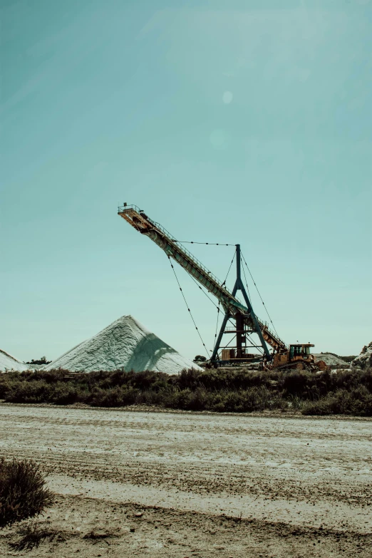 a large crane in the desert near some hills