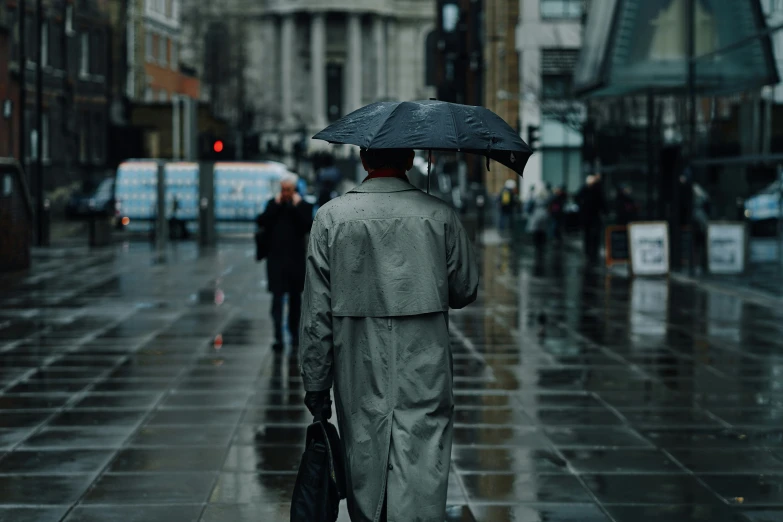 people with umbrellas walking down the street in the rain