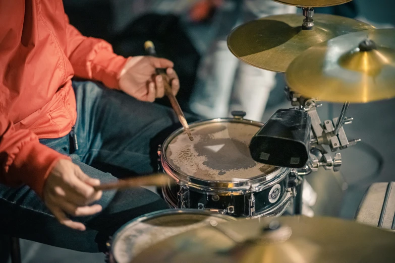 a person sits with drums behind him