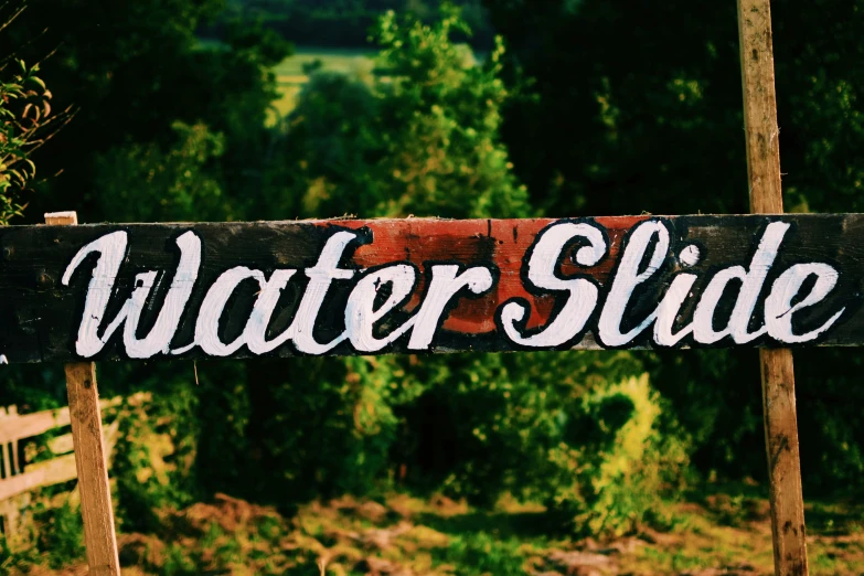 a wooden sign that says water slide in white lettering