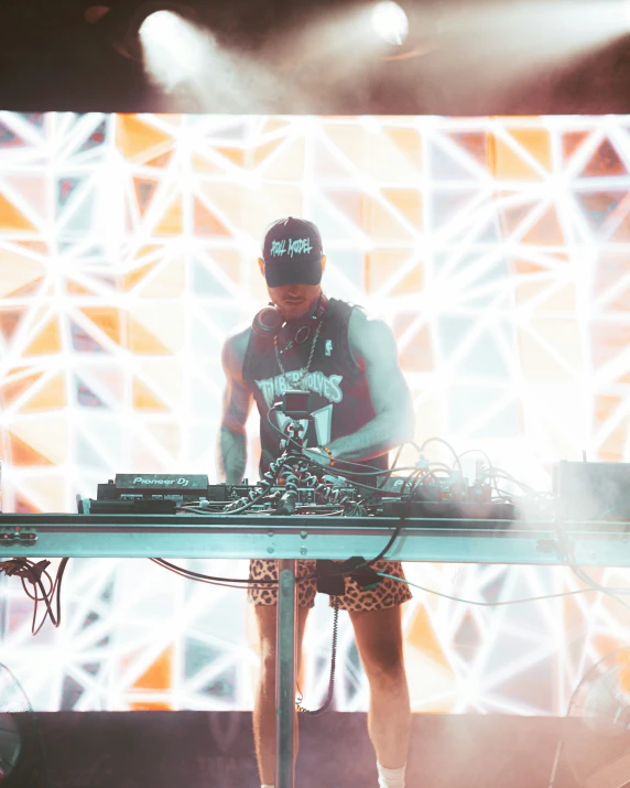a dj standing next to a keyboard on top of a stage