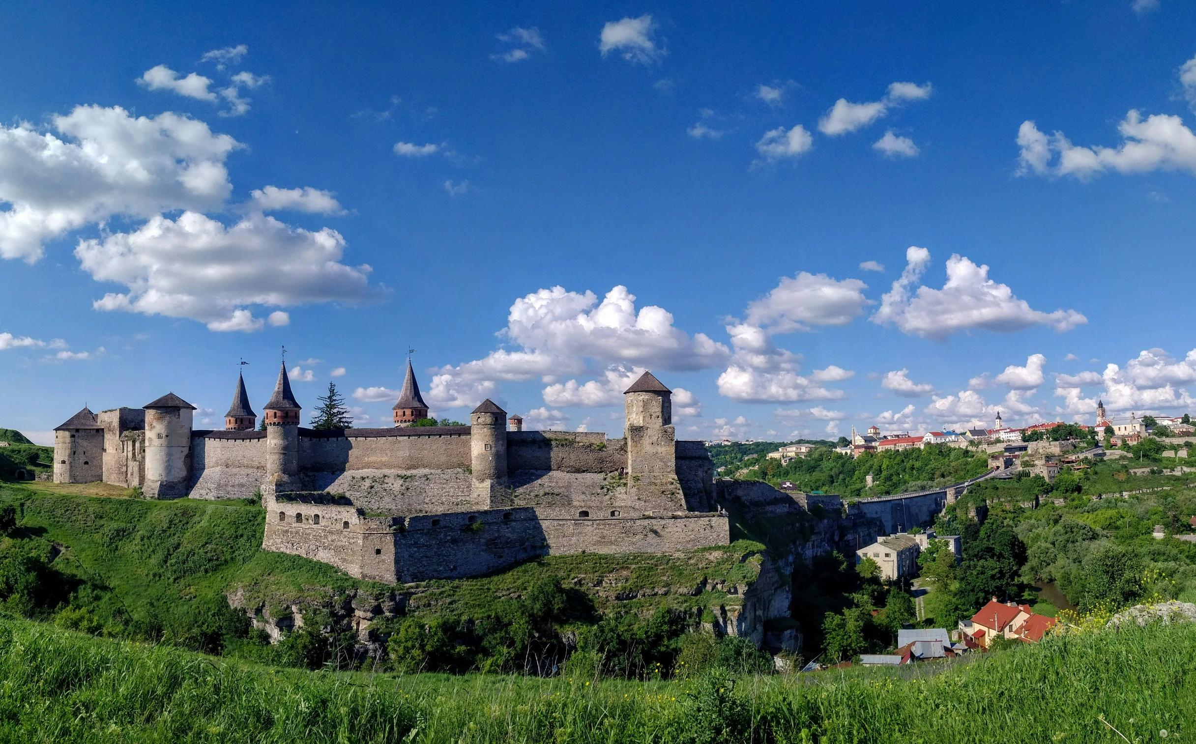 the castle is sitting on a grassy hill