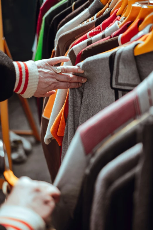 a person holding onto a rack of clothes